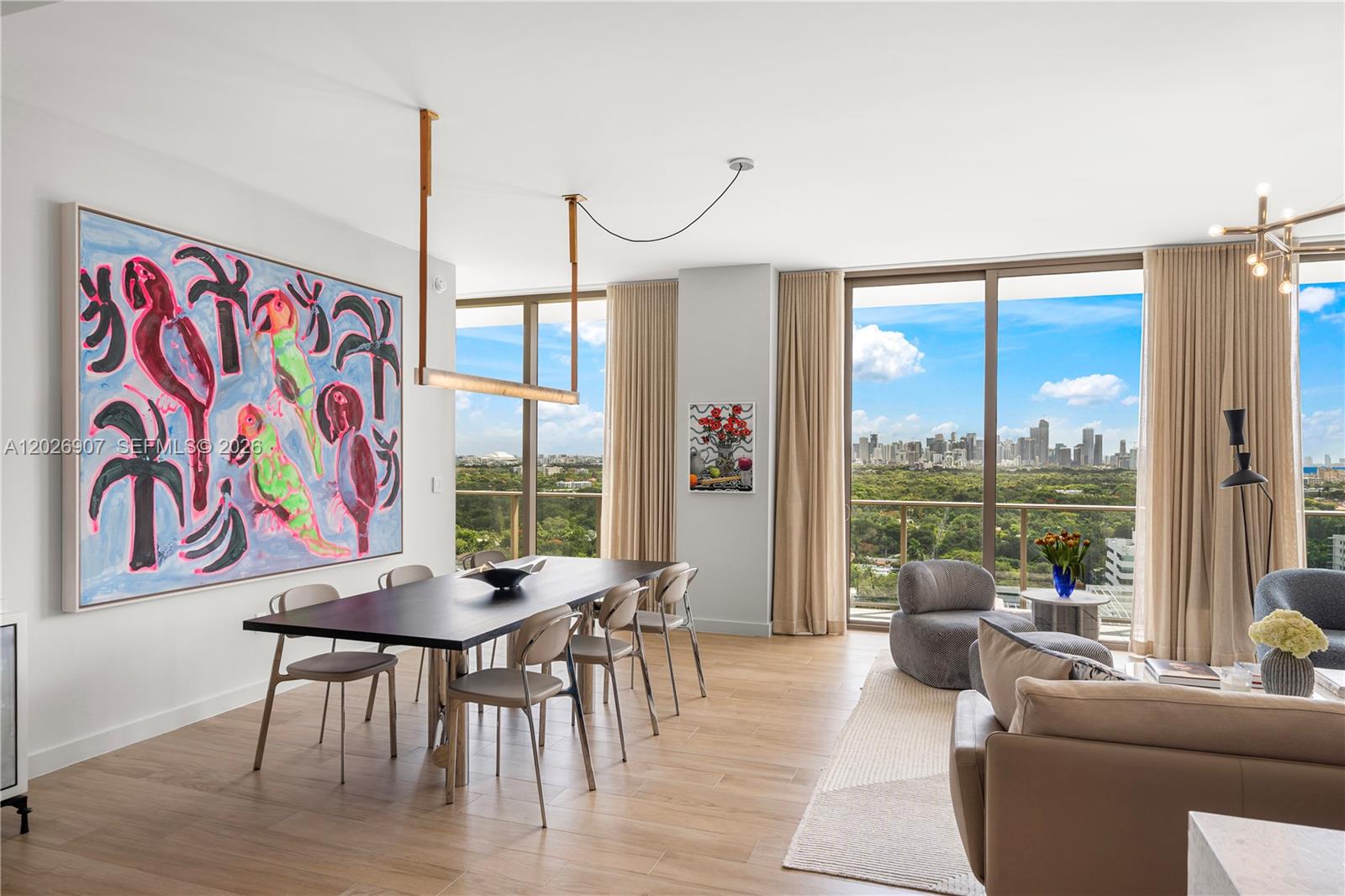 A dining area and living space feature floor-to-ceiling windows with a city skyline view — 2678 Tigertail Ave # 1702, Miami FL 33133, MIAMI, FL