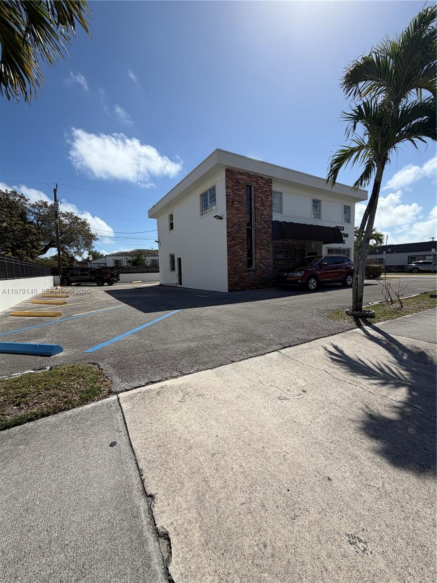 A two-story building with a brick accent wall and a parking lot in front — 1933 SW 27th Ave, Miami FL 33145, MIAMI, FL
