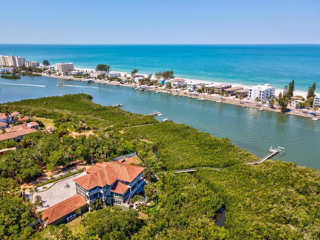 An aerial view shows a large house with a red roof surrounded by dense vegetation — 15041 HARDAGE STREET, LARGO, FL