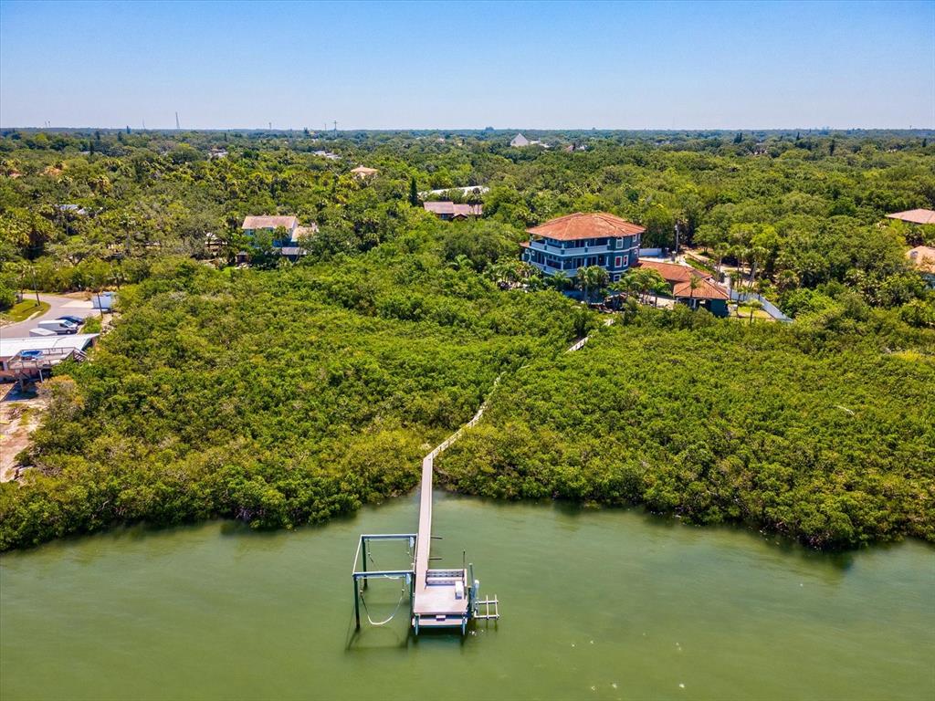 An aerial view shows a house with a long dock extending into the water — 15041 HARDAGE STREET, LARGO, FL