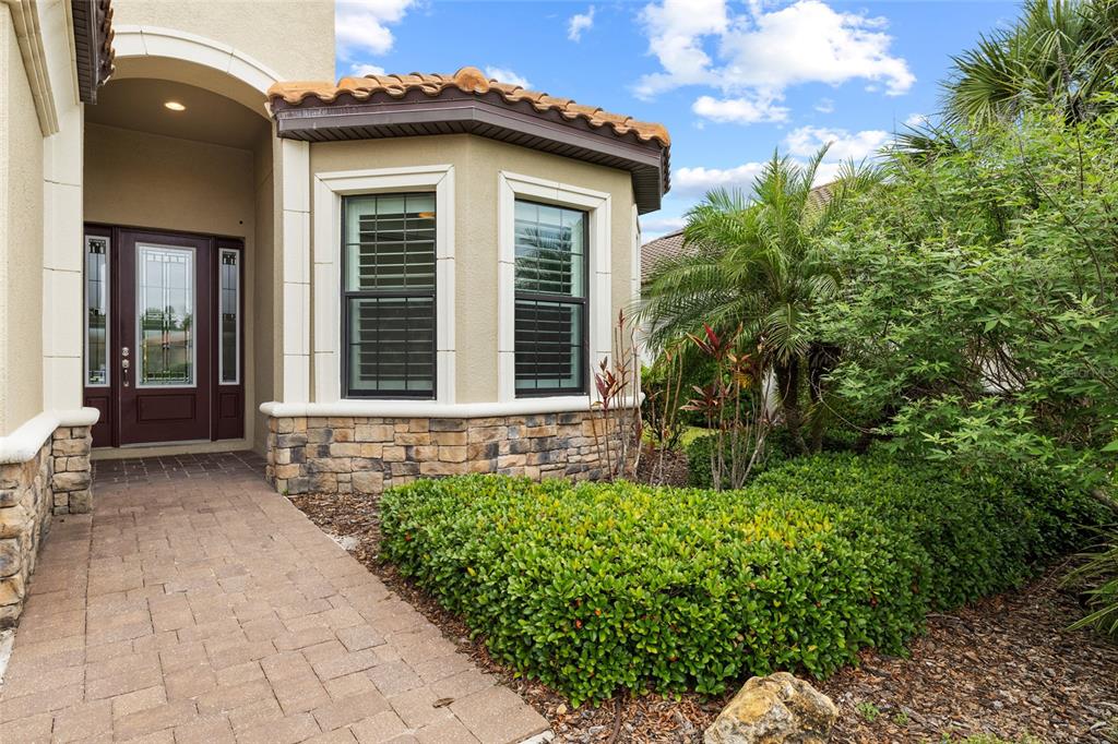 A paved walkway leads to the front entrance of a home with stone accents — 10111 CRAFTSMAN PARK WAY, PALMETTO, FL