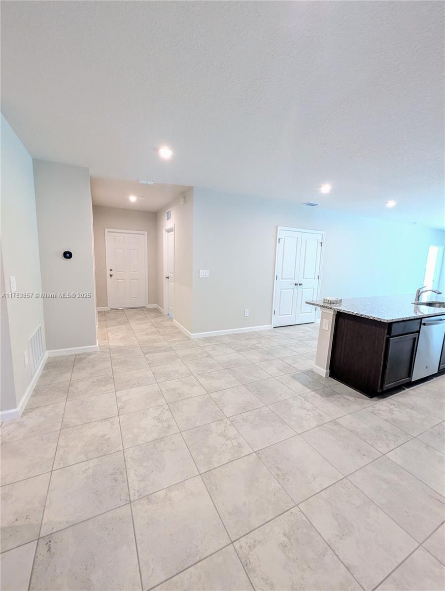 A kitchen island with dark cabinets and granite countertops sits in a tiled room — 285 Raspberry Road # 0, Fort Pierce FL 34981, FORT PIERCE, FL