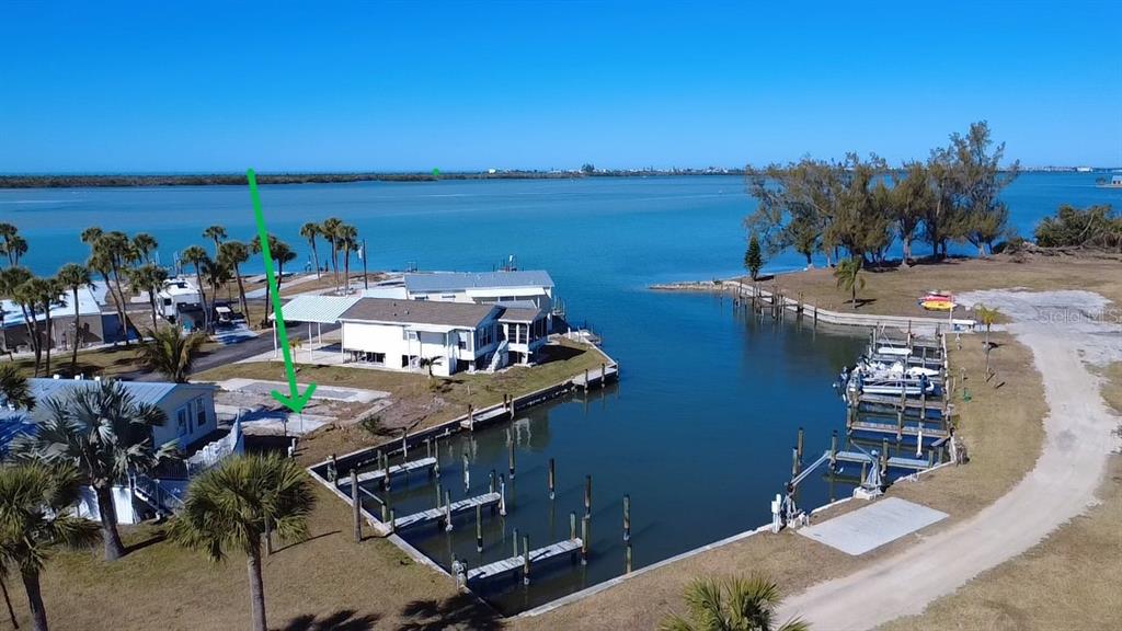 An aerial view shows a waterfront property with a boat slip and a concrete pad — 7500 PARK POINTE DRIVE UNIT 45, ENGLEWOOD, FL