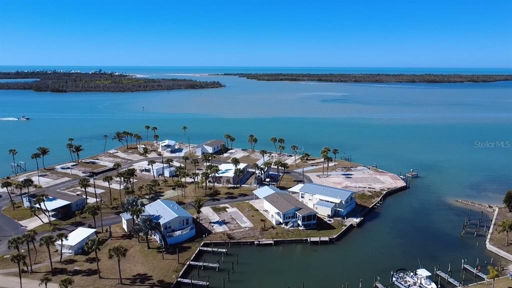 An aerial view shows a waterfront mobile home community with docks and palm trees — 7500 PARK POINTE DRIVE UNIT 45, ENGLEWOOD, FL
