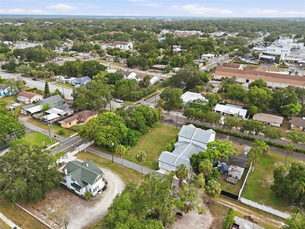 An aerial view shows two houses on a large lot surrounded by trees and neighborhood streets — 5972 CENTRAL AVENUE, NEW PORT RICHEY, FL