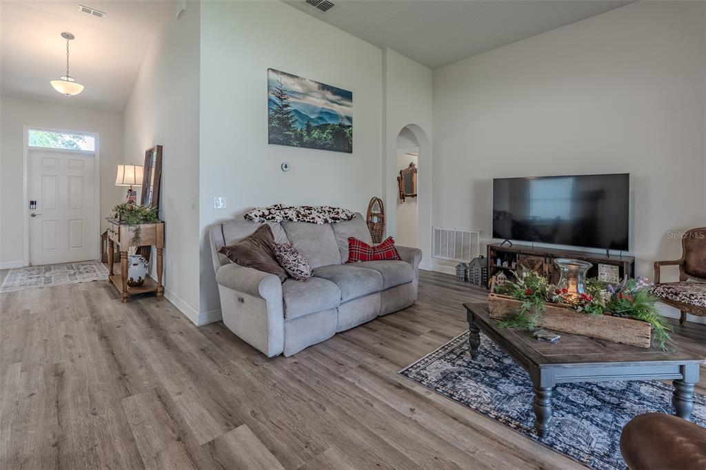 A living room features a gray sofa, a wooden coffee table, and a television console — 9224 SW 60 COURT ROAD, OCALA, FL