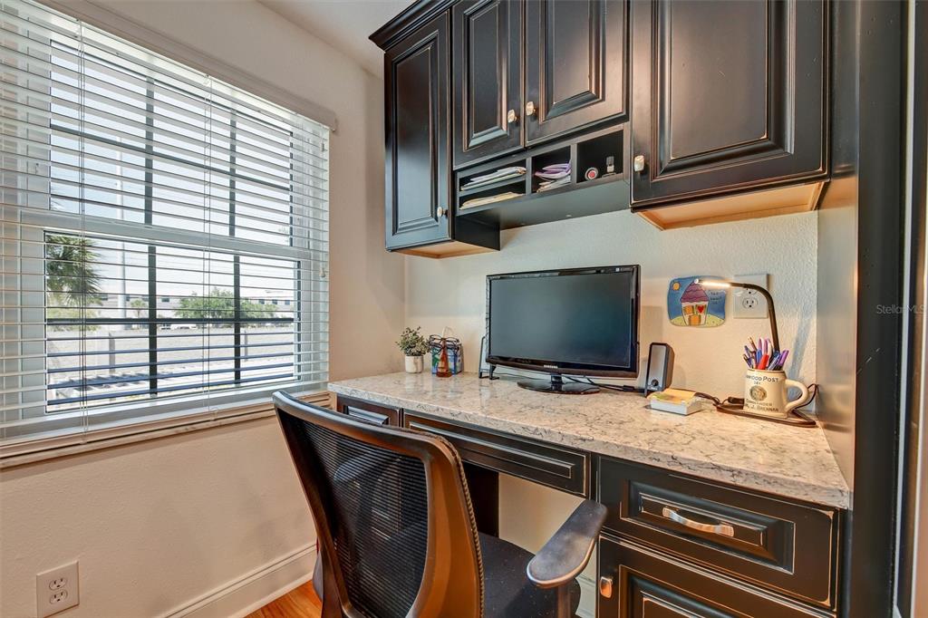 A home office nook features dark wood cabinetry, a granite countertop, and a window — 8352 MEADOWBROOK DRIVE UNIT 10, SEMINOLE, FL