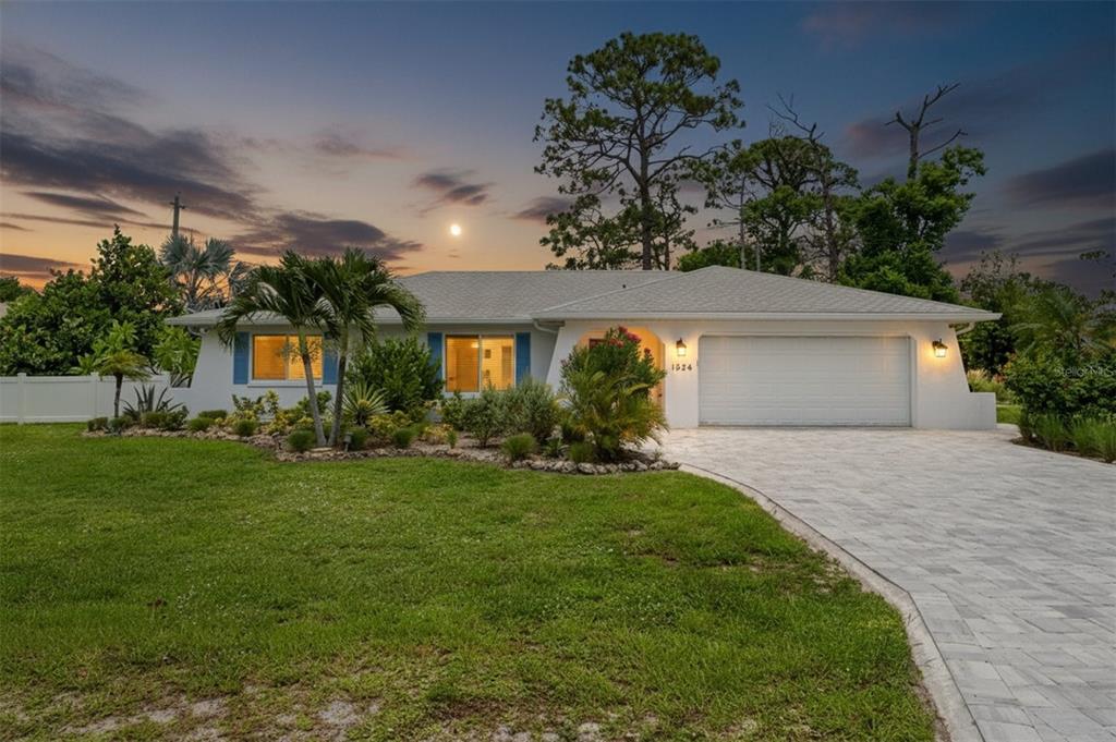 A single-story house with a white exterior, a paved driveway, and a landscaped front yard — 1024 HORIZON ROAD, VENICE, FL