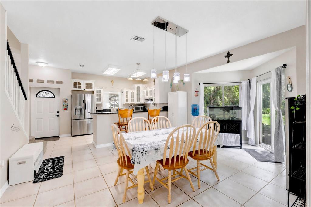 A dining area with a table and chairs sits adjacent to an open-concept kitchen — 5381 ALLIGATOR LAKE ROAD, ST CLOUD, FL