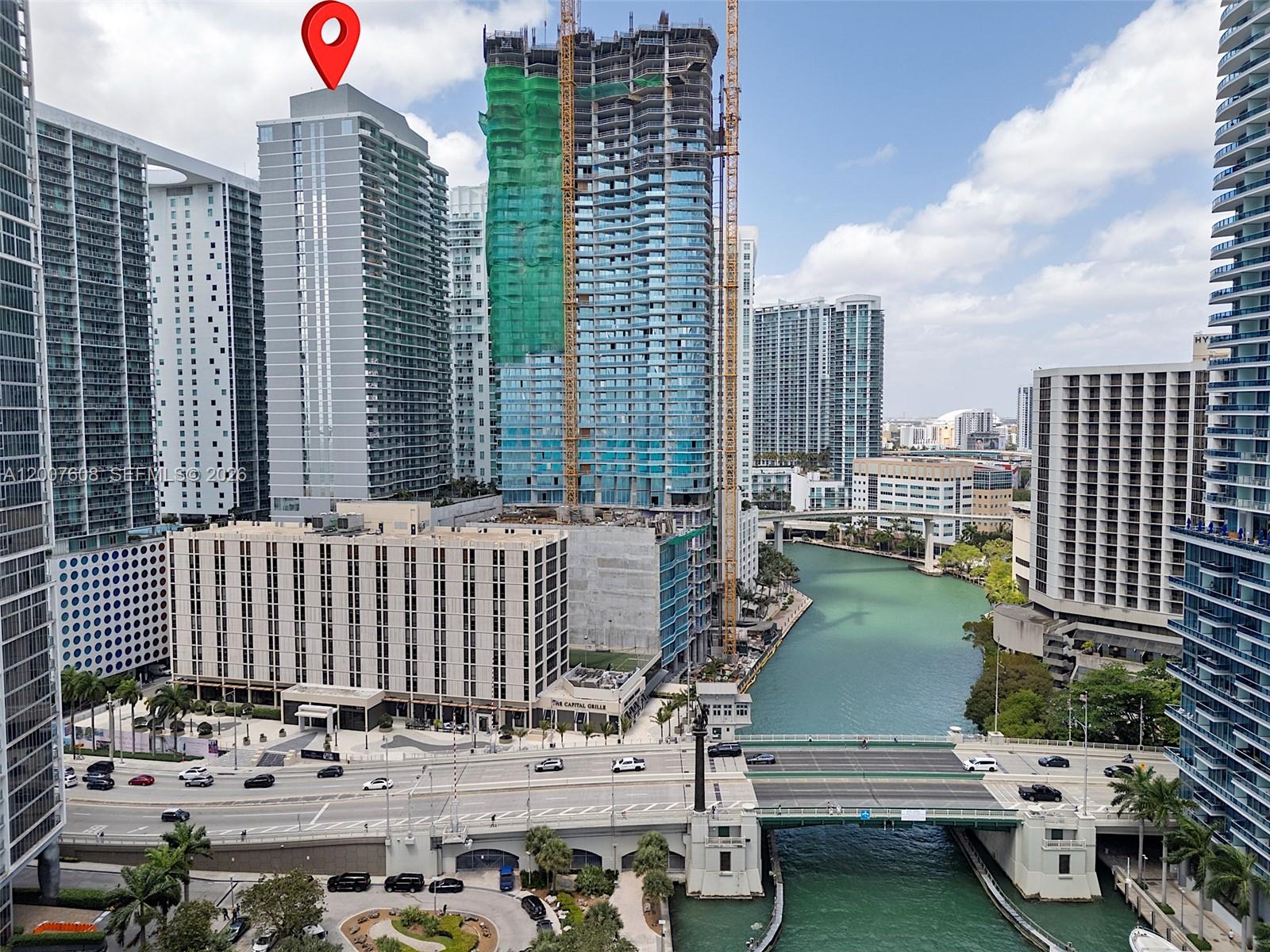 An elevated view of a city skyline featuring high-rise buildings, a river, and a bridge — 77 SE 5th St. # 1510, Miami FL 33131, MIAMI, FL