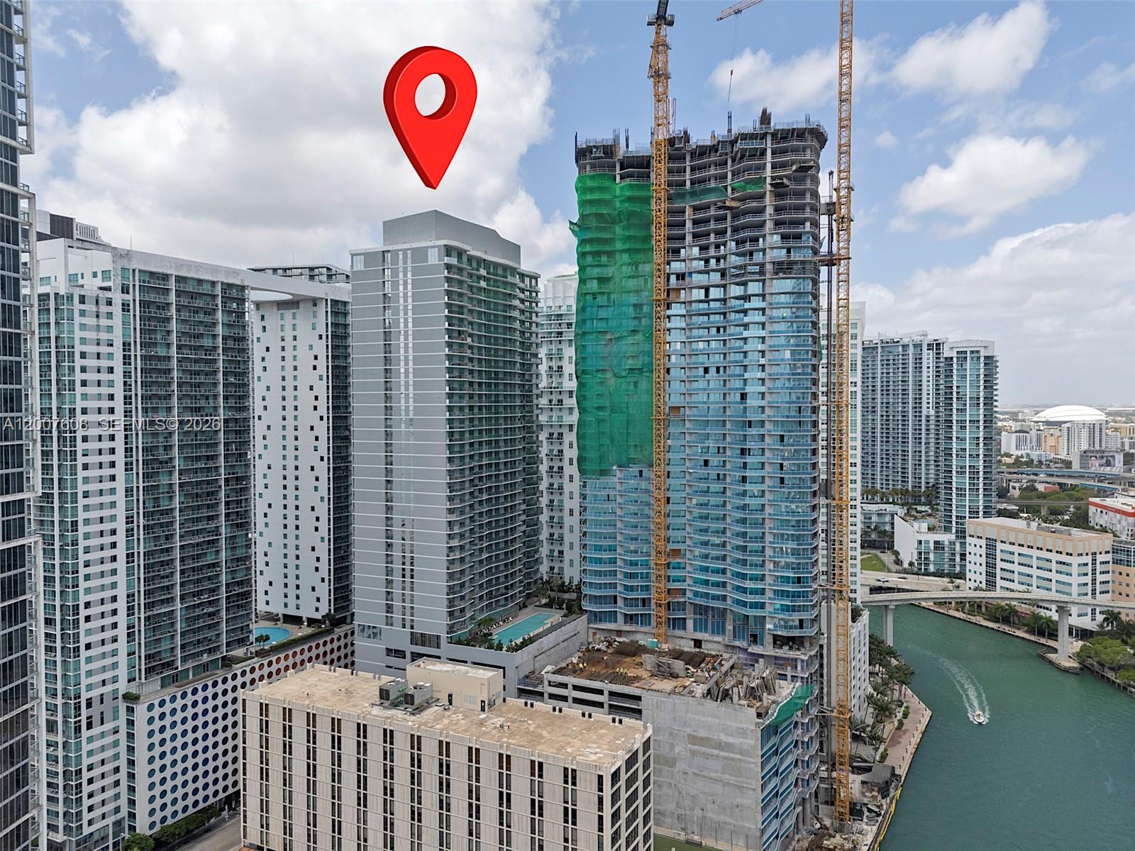 An aerial view shows high-rise residential buildings in a city, including one under construction — 77 SE 5th St. # 1510, Miami FL 33131, MIAMI, FL