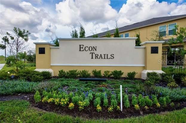 A beige monument sign for Econ Trails stands in front of a multi-story residential building — 9419 TECUMSEH DRIVE, ALAFAYA, FL