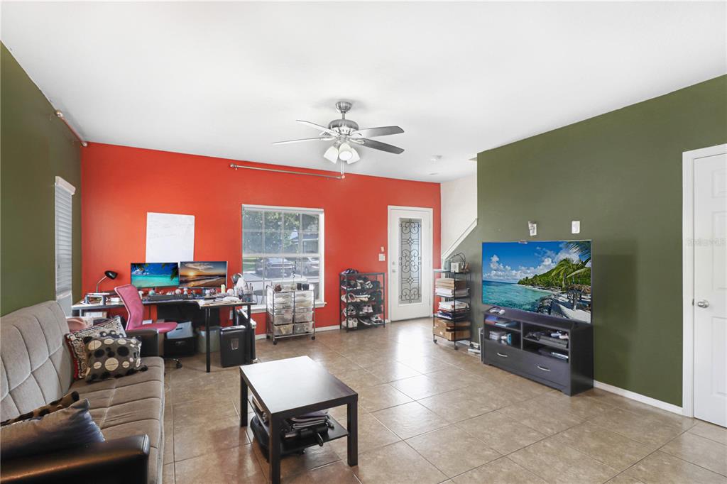 A living room features tile flooring, a red accent wall, and a green accent wall — 4605 SOMERSET HILL LANE, RIVERVIEW, FL