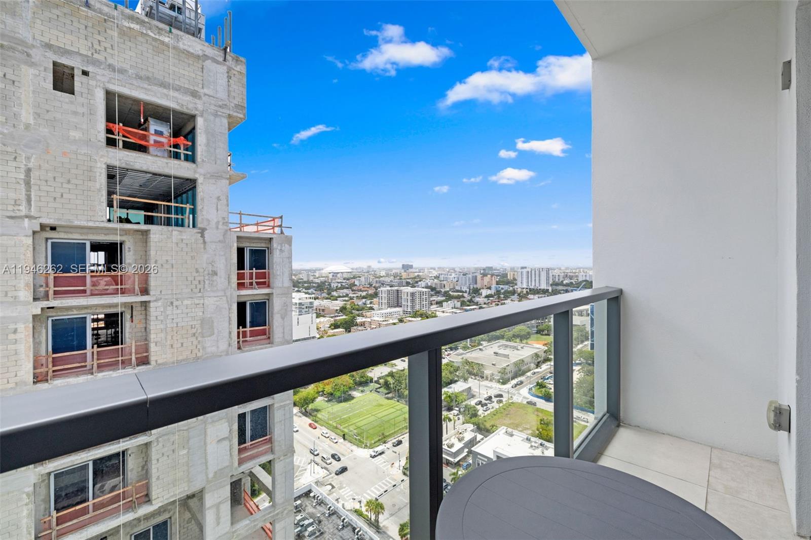 A balcony overlooks a city street and a neighboring building under construction — 239 SW 9th St # 2303, Miami FL 33130, MIAMI, FL