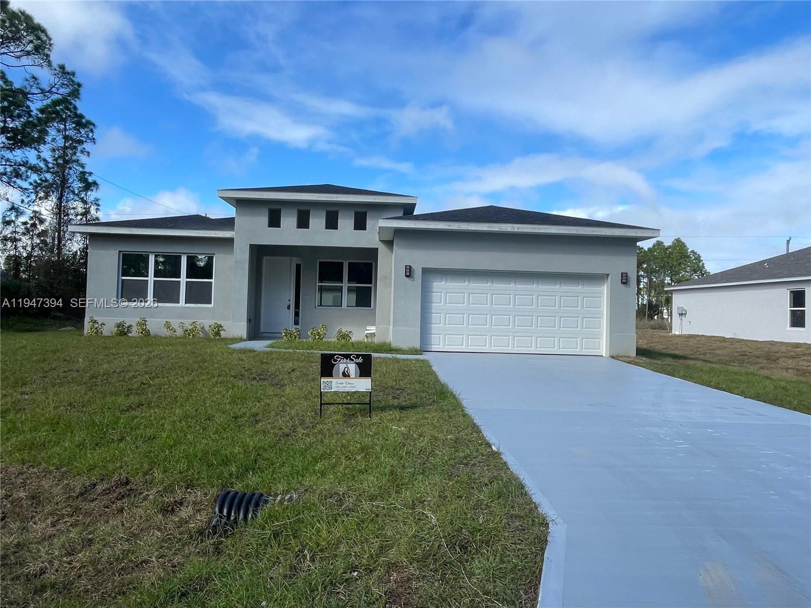 A single-story gray house features a two-car garage, a front lawn, and a for-sale sign — 1326 SEQUOIA RD, Palm Bay FL 32907, PALM BAY, FL