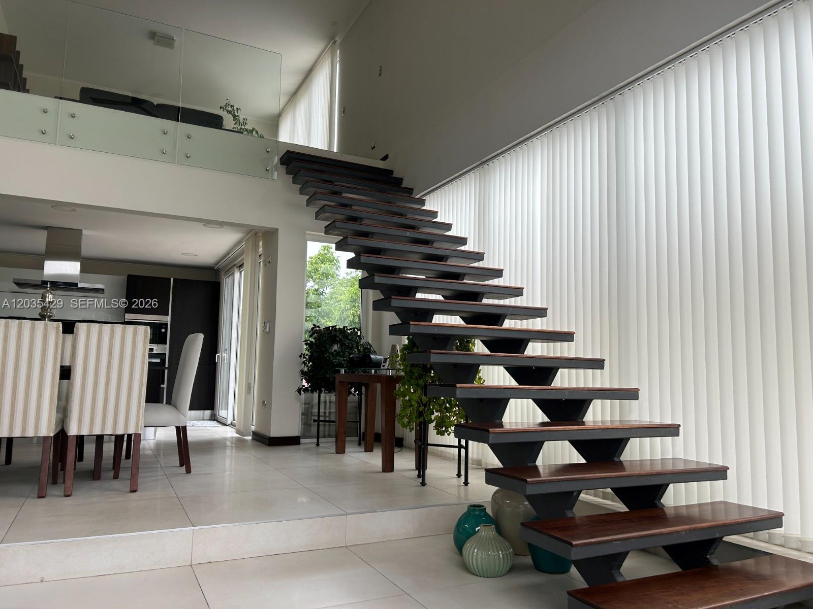 A modern living area features a floating staircase with dark wood treads and metal supports — Parcela 12 A Los Molles, OC, OC