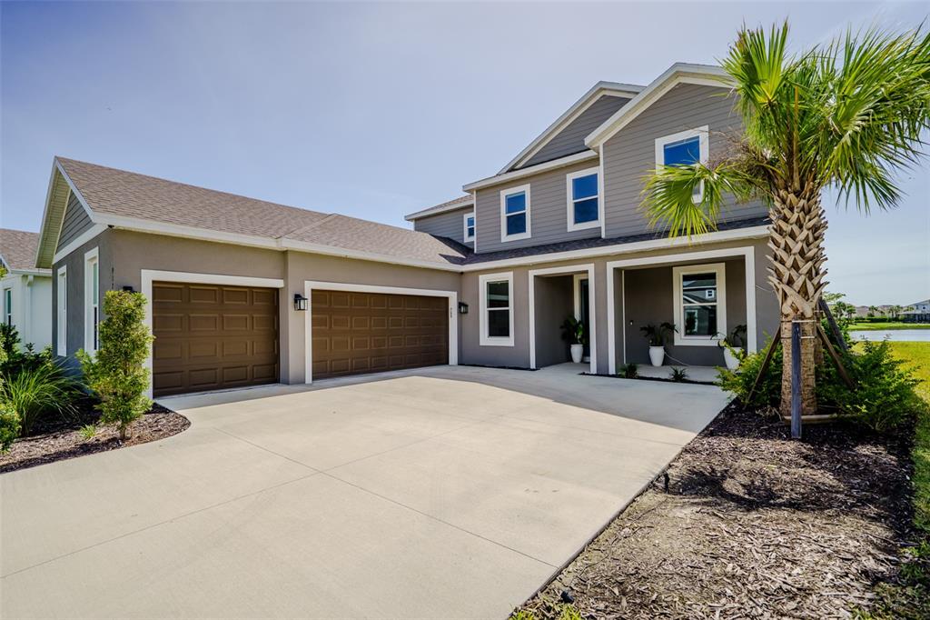 A two-story house with a three-car garage and a palm tree in the front yard — 9121 RADIANT CIRCLE, SARASOTA, FL