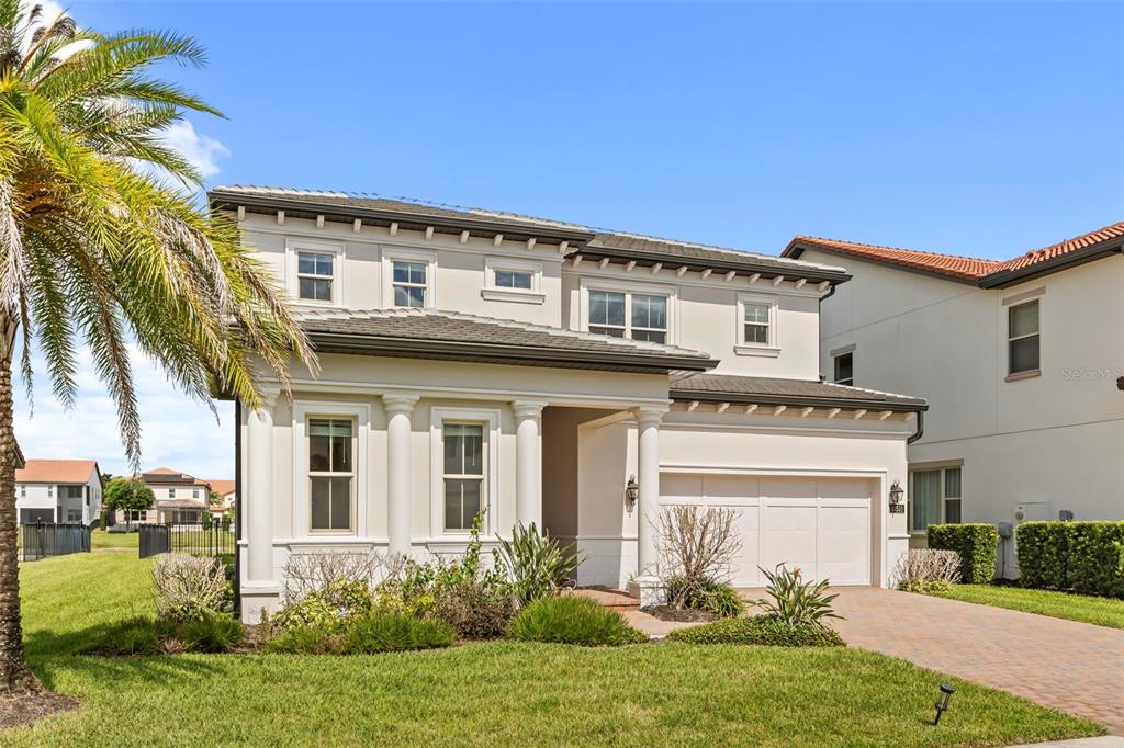 A two-story, light-colored stucco house with a tiled roof, columns, and a paved driveway — 10511 ROYAL CYPRESS WAY, ORLANDO, FL