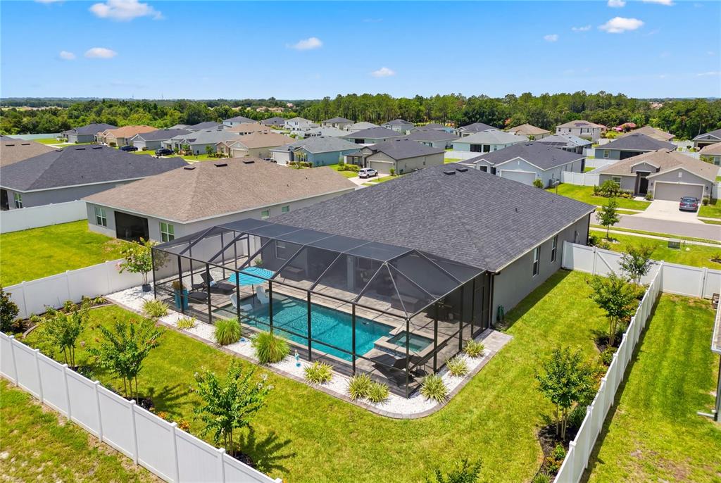 A screened-in patio features a swimming pool, a hot tub, and lounge chairs — 1185 SANDPIPER LOOP, WINTER HAVEN, FL
