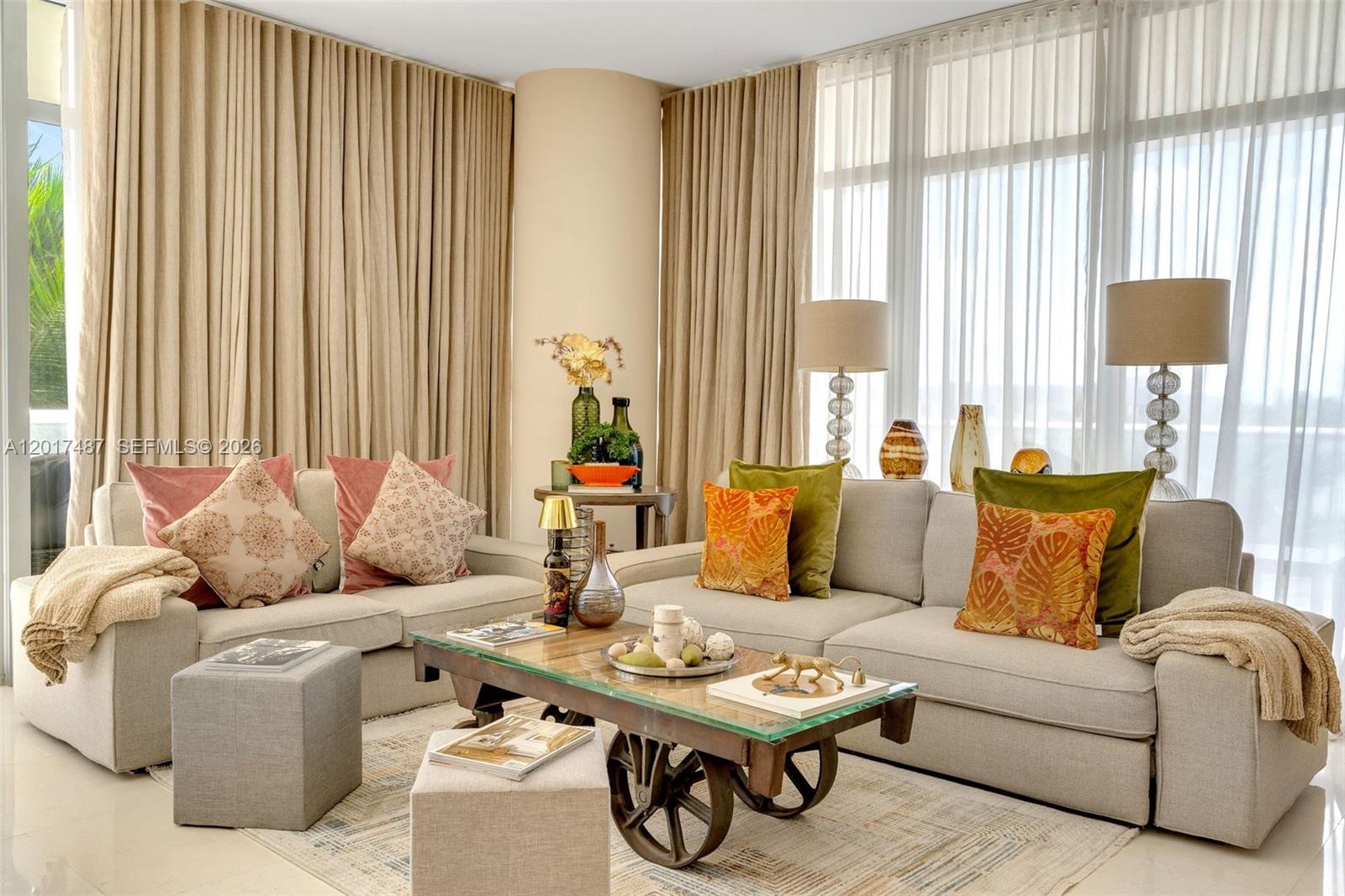 A living room features two beige sofas, a glass-topped coffee table with wheels, and floor-to-ceiling curtains — 3737 Collins Ave # 403, Miami Beach FL 33140, MIAMI BEACH, FL