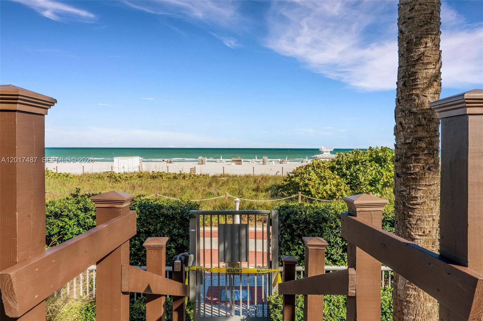 A wooden staircase leads down to a gated beach access path overlooking the ocean — 3737 Collins Ave # 403, Miami Beach FL 33140, MIAMI BEACH, FL