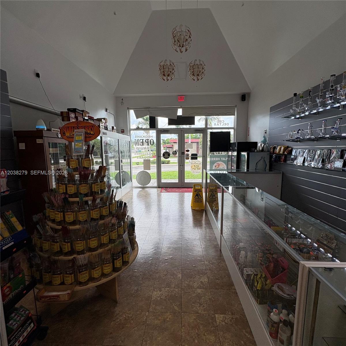 A retail store interior features a central incense display, glass counters, and wall-mounted glass pipes — 5901 Johnson St, Hollywood FL 33021, HOLLYWOOD, FL