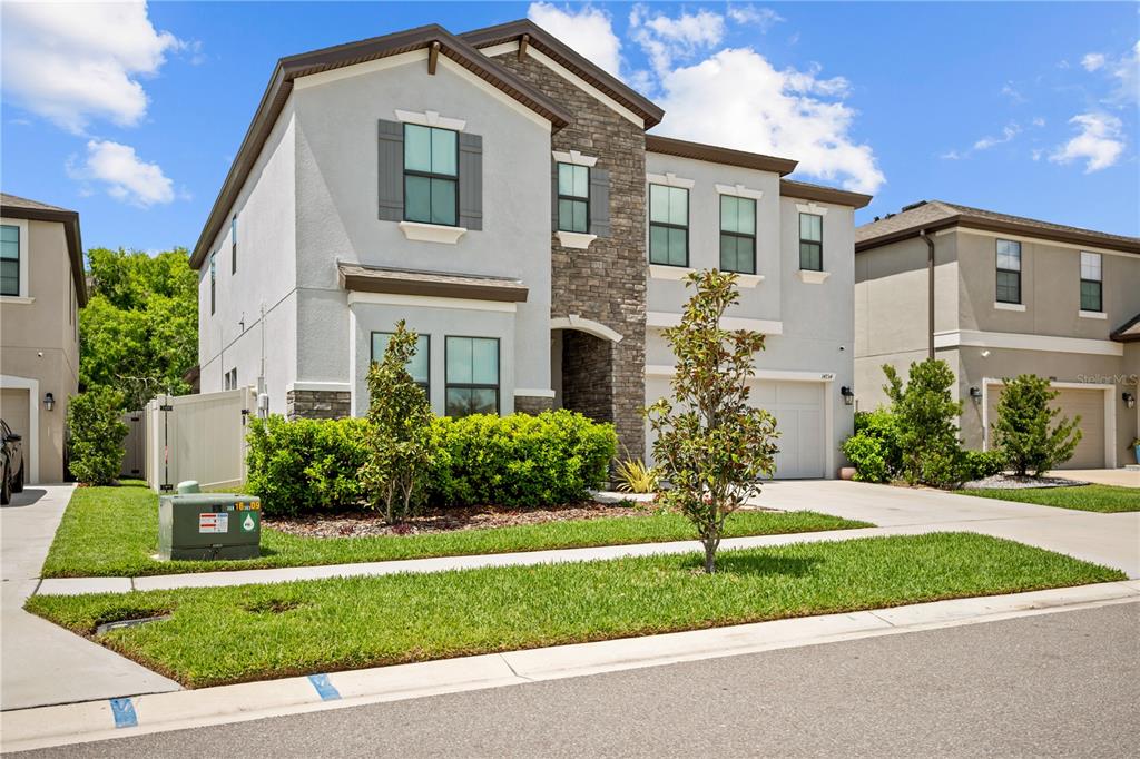 A two-story suburban house with a stone facade, gray stucco, and a two-car garage — 14734 HORSE TROT ROAD, LITHIA, FL
