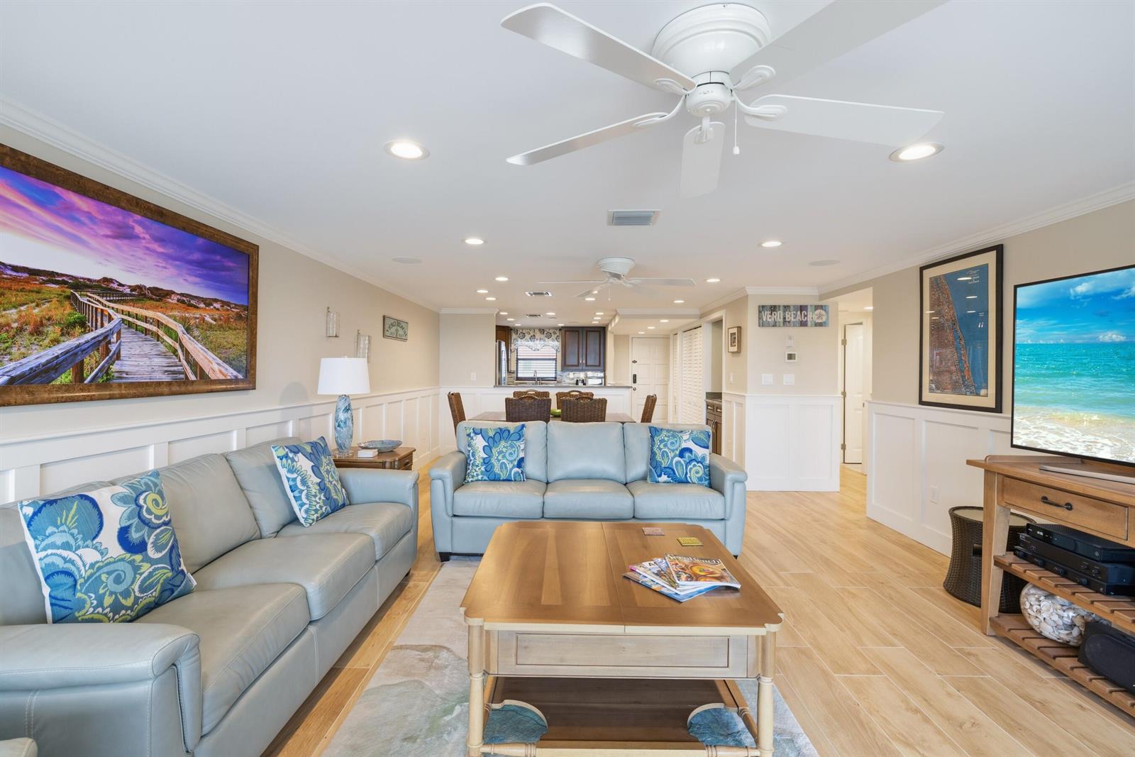 A living room features light blue leather sofas, a wooden coffee table, and wood-look flooring — INDIAN RIVER SHORES, FL