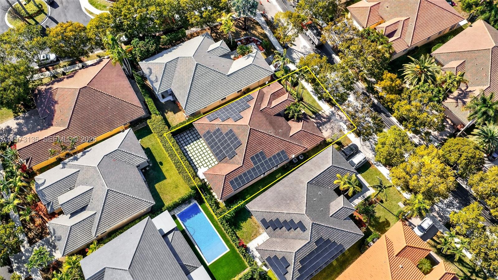 An aerial view shows a residential house with solar panels and a swimming pool — 1623 Blue Jay Cir, Weston FL 33327, WESTON, FL