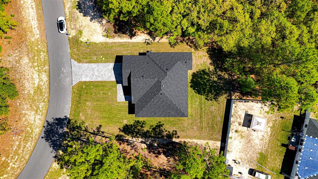 An aerial view shows a house with a dark roof situated on a wooded lot — 15267 SW 50TH COURT ROAD, OCALA, FL