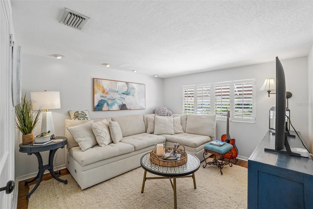 A living room features a beige sectional sofa, a round coffee table, and a television — 1204 E PARK CIRCLE, TAMPA, FL