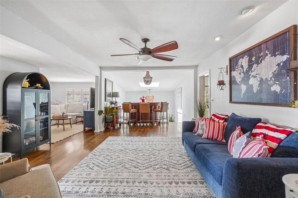 A living room with a blue sofa, patterned rug, and a bar area in back — 1204 E PARK CIRCLE, TAMPA, FL