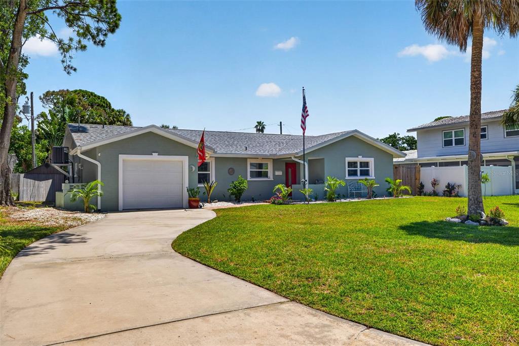 A single-story house with a light green exterior, a white garage door, and a front lawn — 1667 N DAKOTA AVENUE NE, ST PETERSBURG, FL