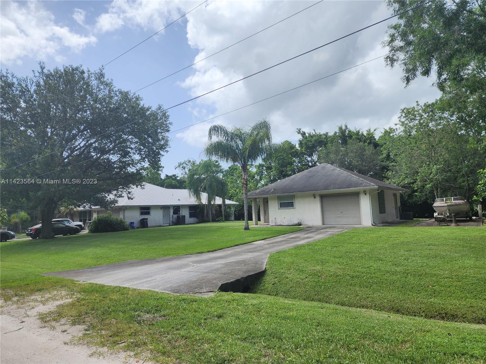 A single-story house with a garage and a concrete driveway sits on a grassy lot — 11845 N 171st Ln N, Jupiter FL 33478, JUPITER, FL