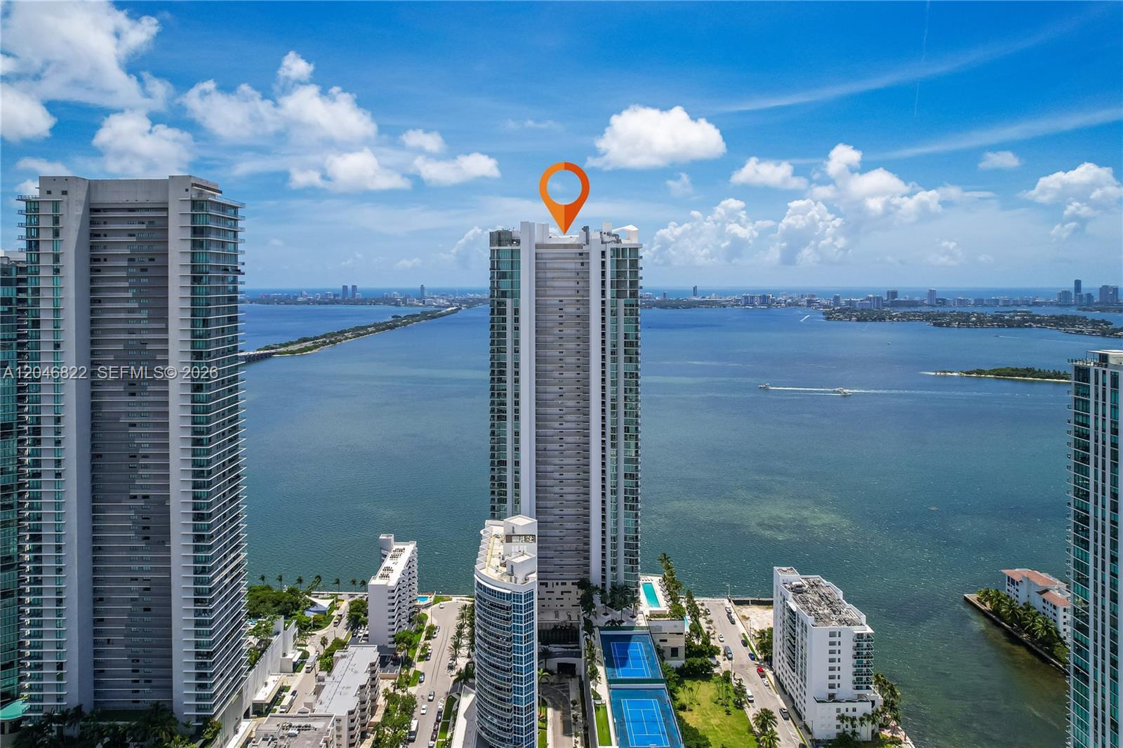 A modern dining area and kitchen with a glass table, bar seating, and floor-to-ceiling windows — 2900 NE 7th Ave # 4308, Miami FL 33137, MIAMI, FL