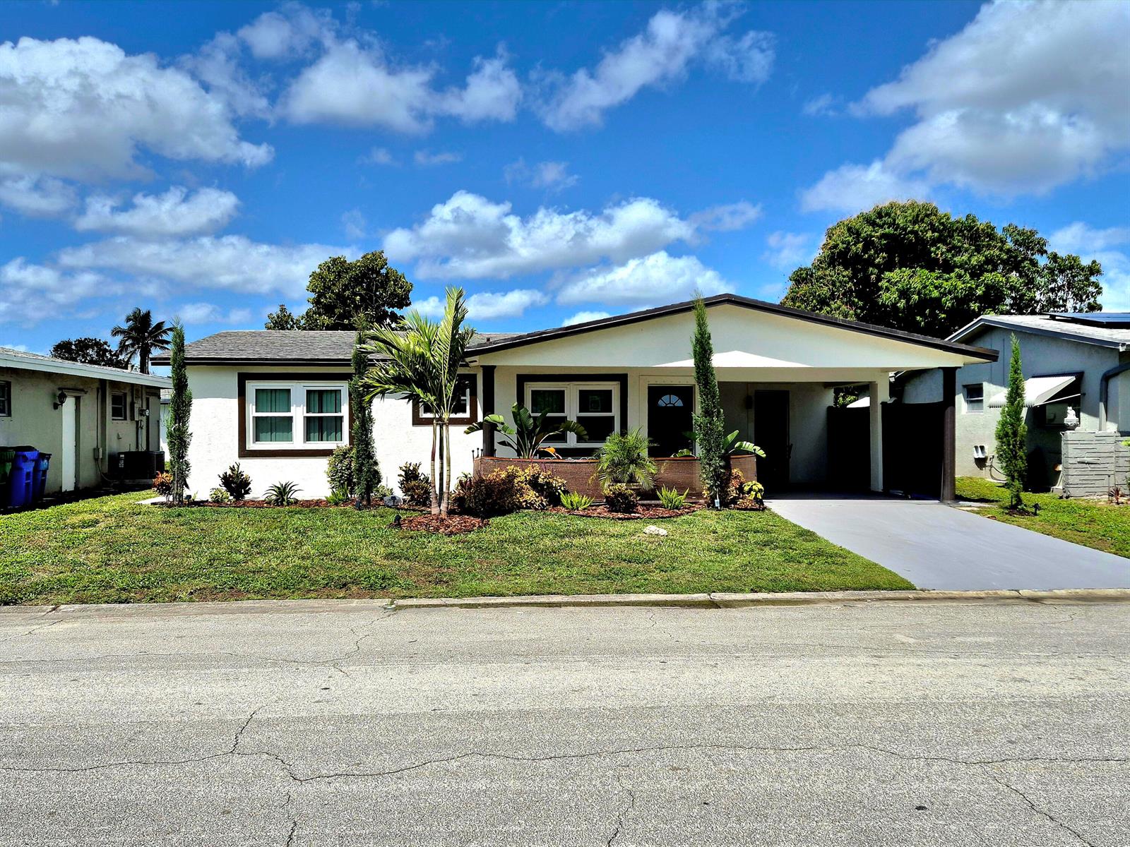 A single-story house with a white exterior, a front carport, and a landscaped front yard — 1015 NW 68th Avenue, Margate FL 33063, MARGATE, FL