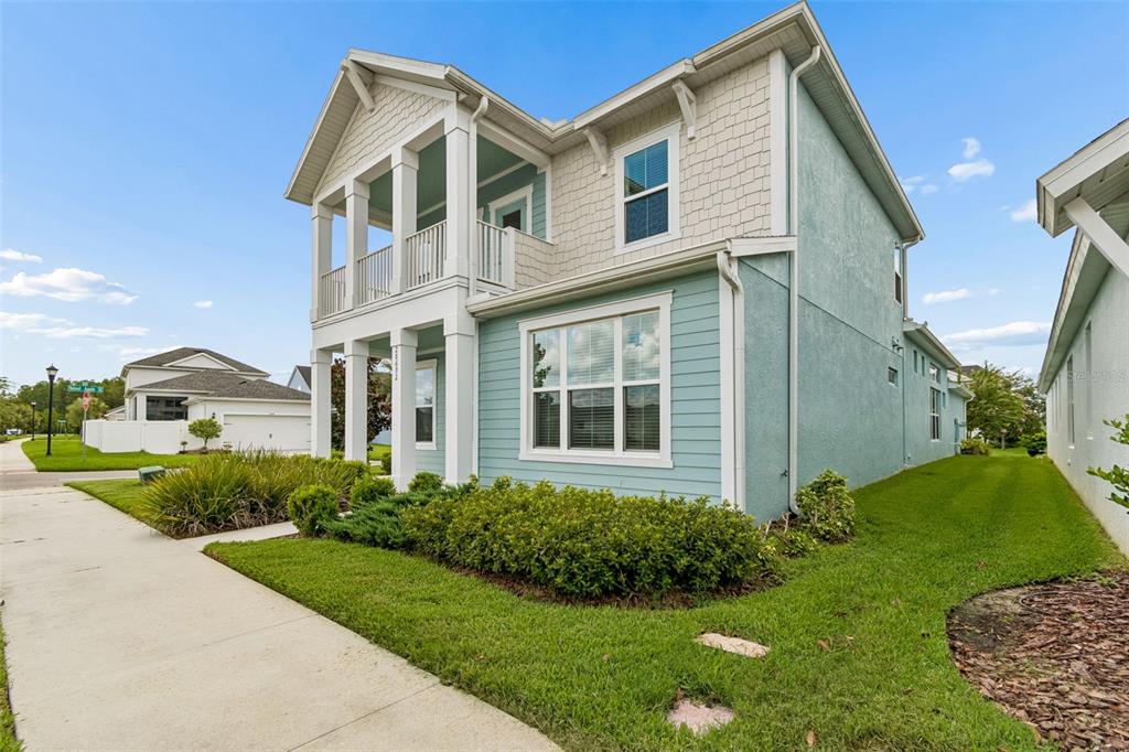 A two-story house with light blue siding, a front porch, and a second-floor balcony — 28692 COZY CREEK DRIVE, WESLEY CHAPEL, FL