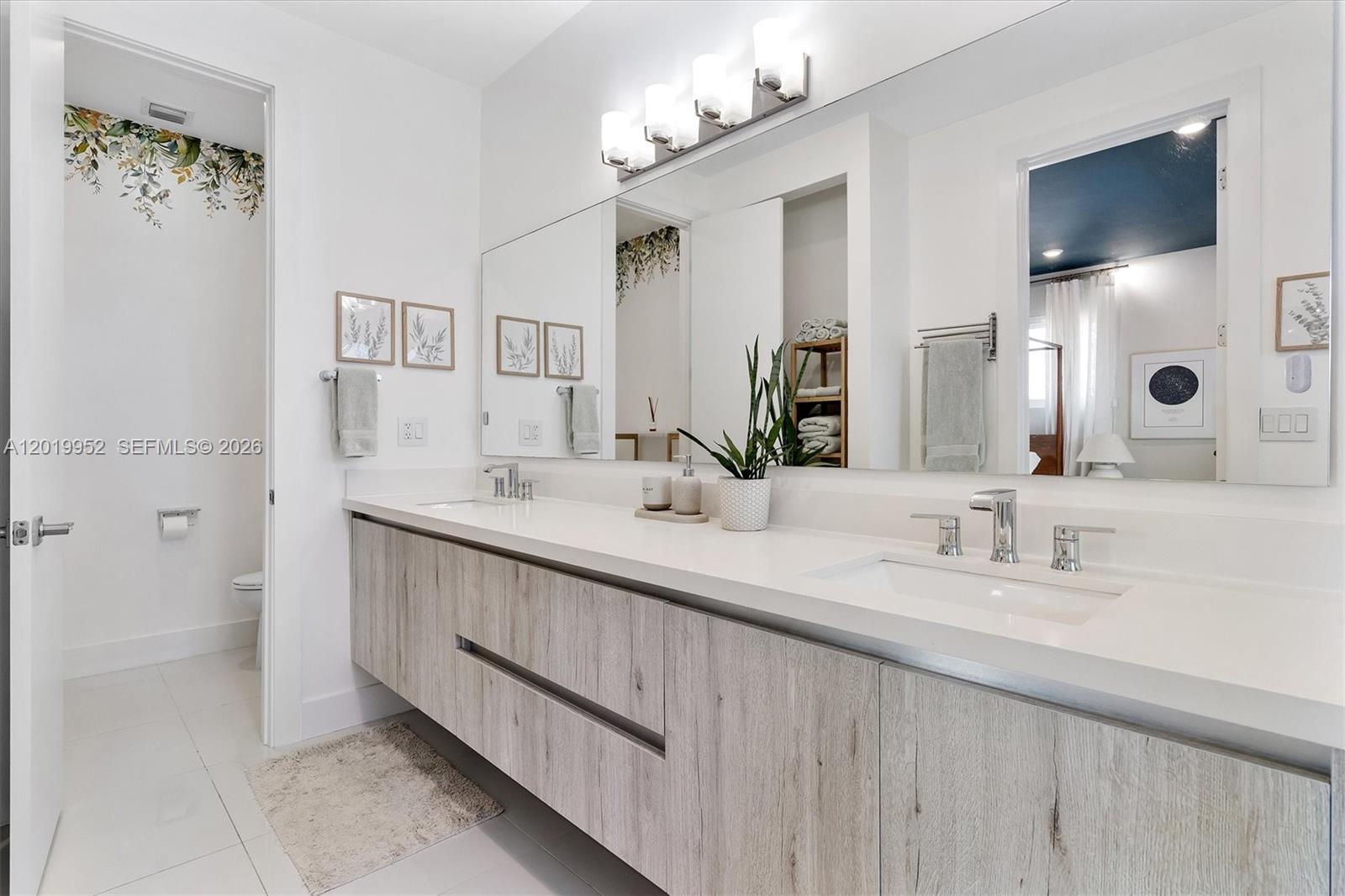 A modern bathroom features a floating wood-grain vanity with double sinks and a large mirror — 2920 SW 25th Ter # B, Miami FL 33133, MIAMI, FL