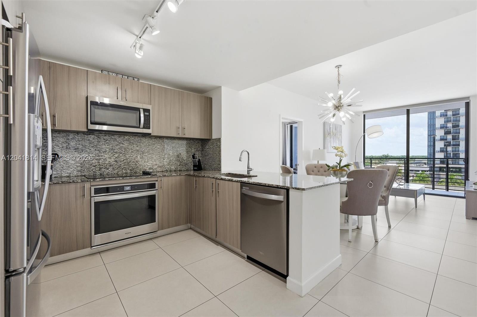 A modern kitchen features light wood cabinets, granite countertops, and stainless steel appliances — 5350 NW 84th Ave # 504, Doral FL 33166, DORAL, FL