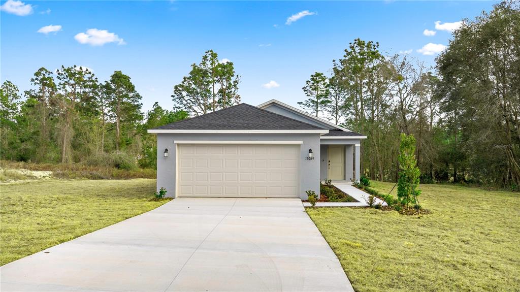 A single-story house with a gray exterior, a two-car garage, and a concrete driveway — 8140 SW 44TH TERRACE, OCALA, FL