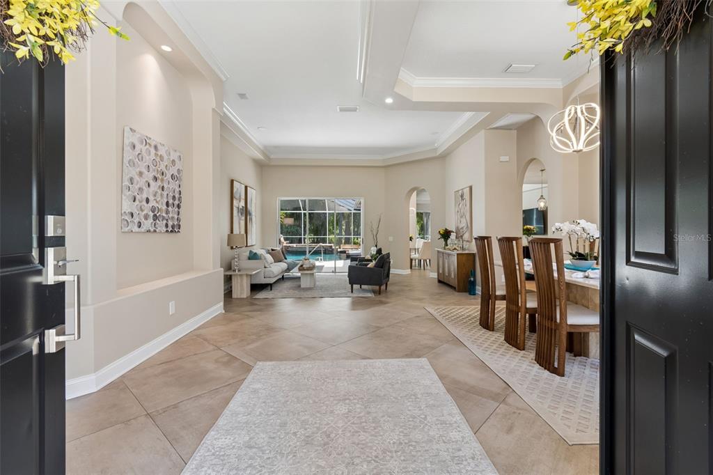 A view from an entryway into a living and dining area with tile floors — 10423 GREENHEDGES DRIVE, TAMPA, FL