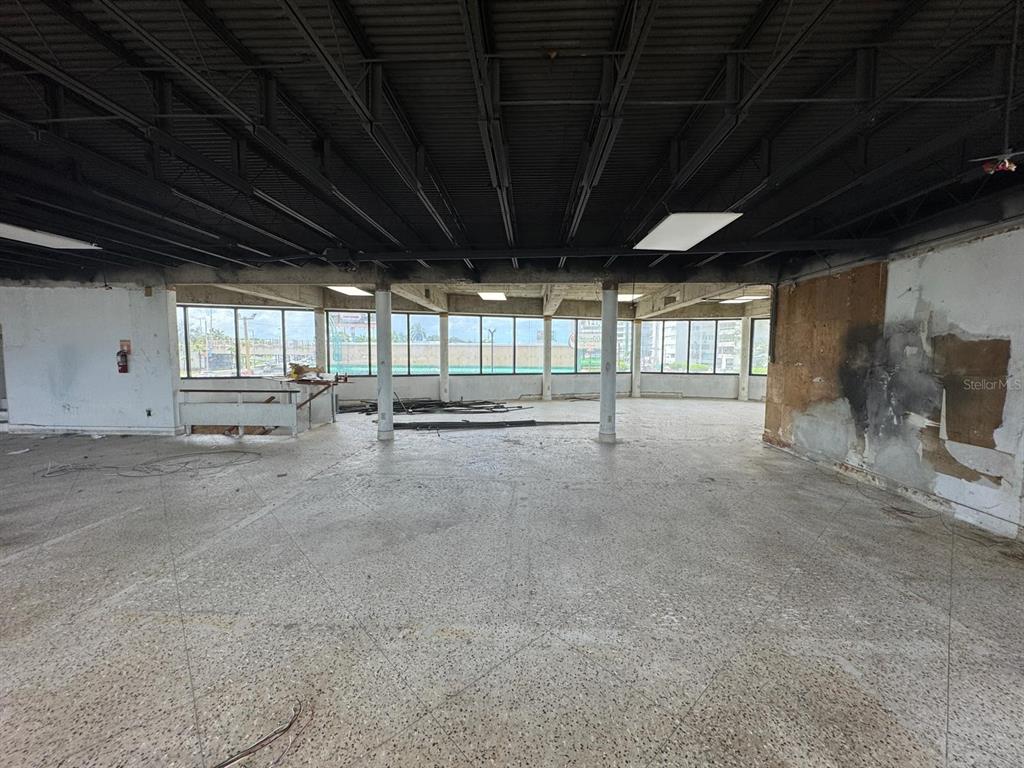 An empty commercial space features a concrete floor, exposed ceiling, and large windows — 1064 AV. ISLA VERDE, CAROLINA, PR