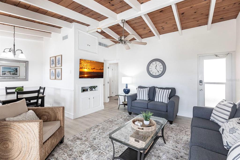 A living room features a wood-paneled ceiling, a ceiling fan, and gray upholstered furniture — 6006 MIDNIGHT PASS ROAD UNIT 14, SARASOTA, FL