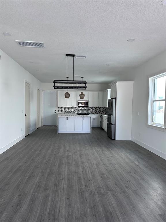 A kitchen with white cabinets, a patterned backsplash, and a central island with pendant lighting — 1525 29TH AVENUE N, ST PETERSBURG, FL