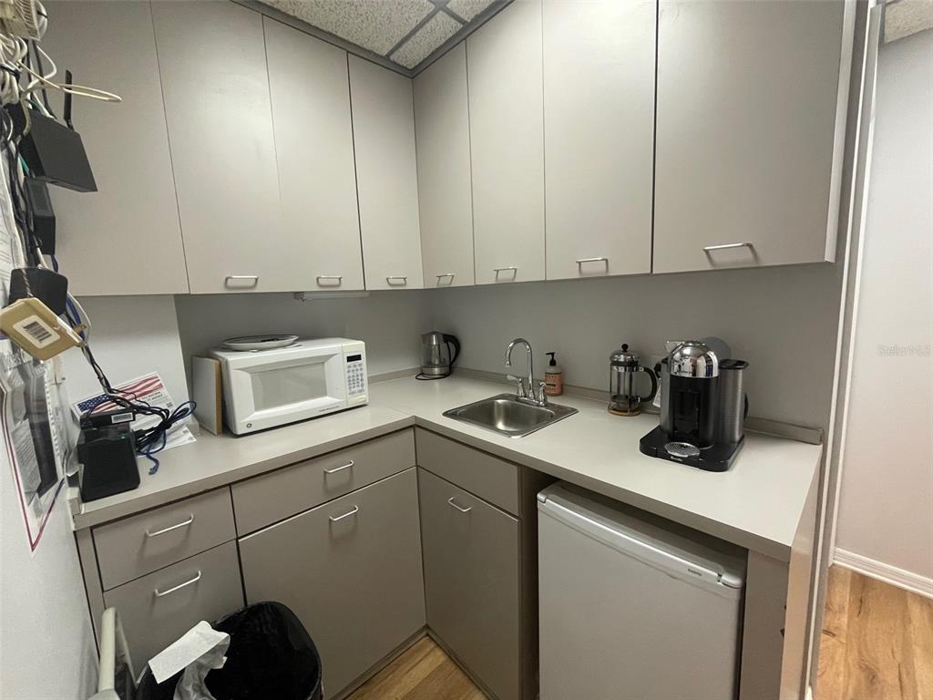 A small kitchenette features gray cabinets, a microwave, a sink, and a mini refrigerator — 1219 S EAST AVENUE UNIT 3-304, SARASOTA, FL