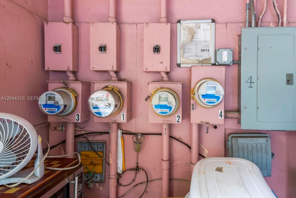 Four electrical meters and a large breaker panel are mounted on a pink wall — 519 NW 10th Ave # 3, Miami FL 33136, MIAMI, FL
