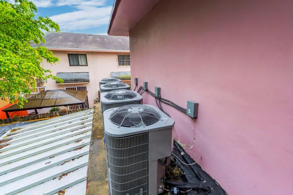 Three air conditioning units sit on a flat roof next to a pink exterior wall — 519 NW 10th Ave # 3, Miami FL 33136, MIAMI, FL