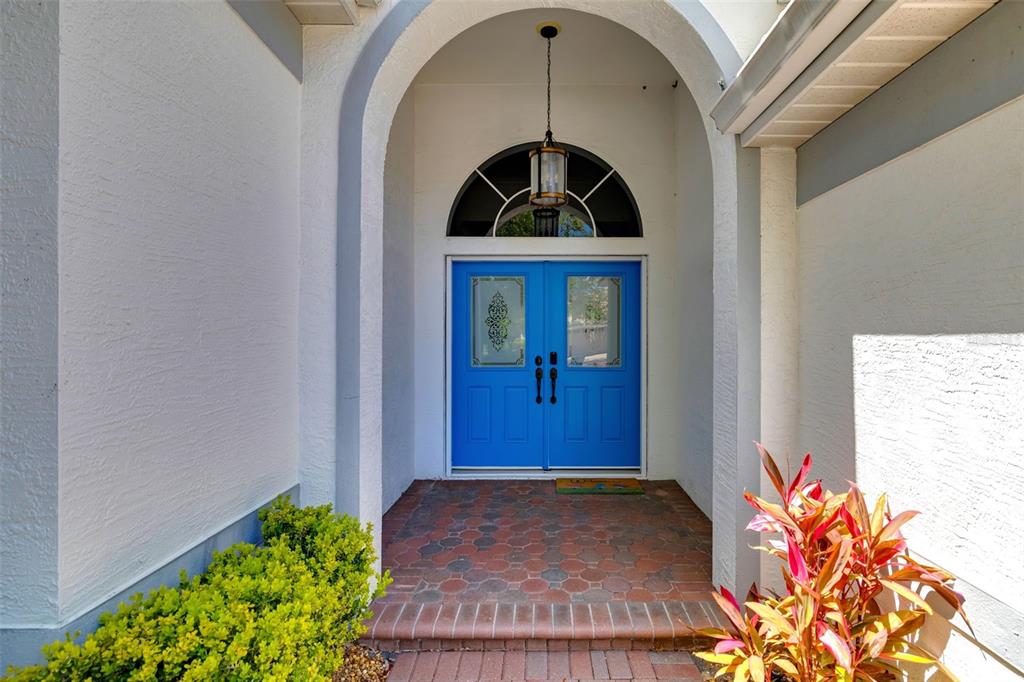 A bright blue double front door is set within a white arched entryway — 6413 GRAND POINT AVENUE, BRADENTON, FL