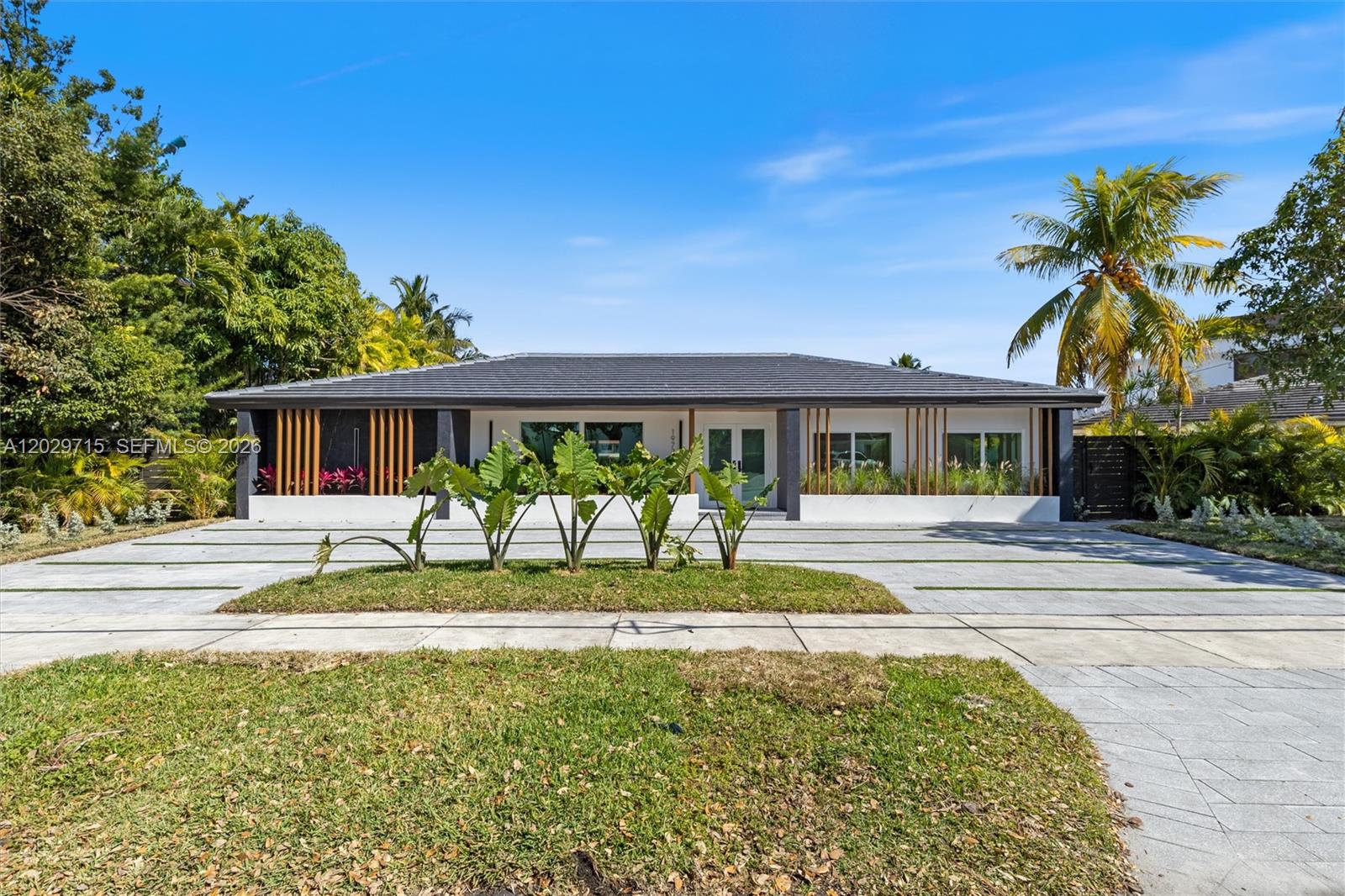 A single-story house with a gray tiled roof, white facade, and vertical wood slat accents — 19721 NE 23rd Ave # 19721, Miami FL 33180, MIAMI, FL