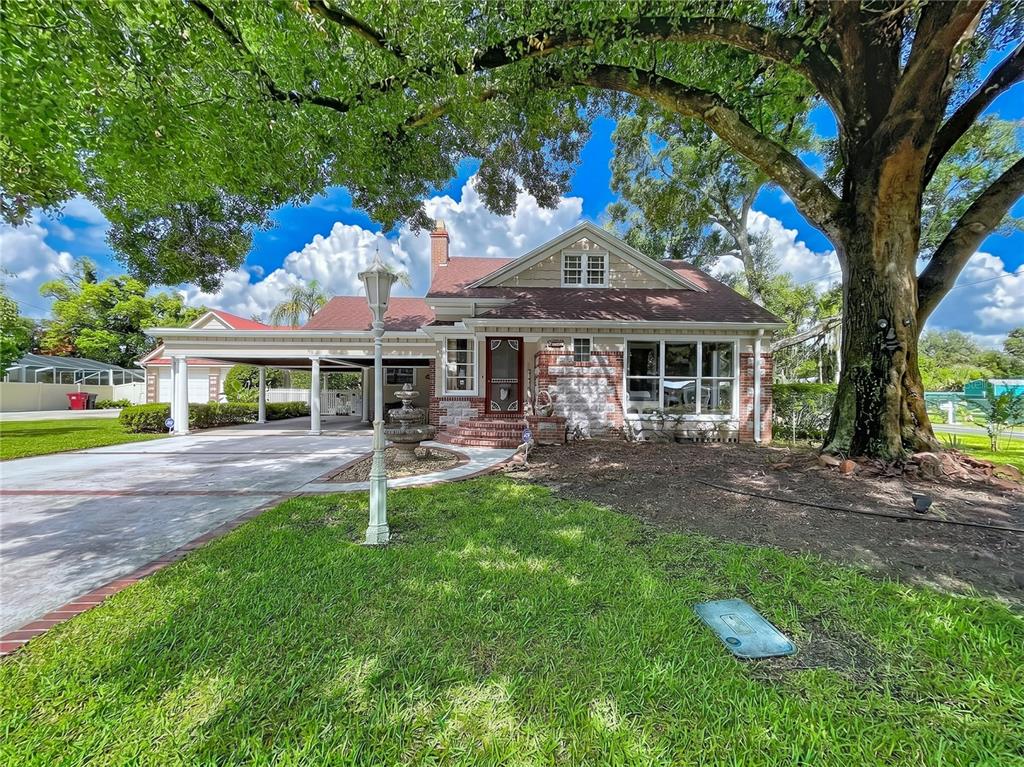 A single-story brick house with a carport, a large tree, and a front lawn — 607 N MERRIN STREET, PLANT CITY, FL